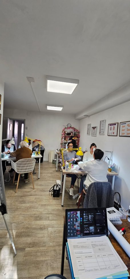 Salle de réunion avec des personnes assises autour de tables, travaillant ensemble.